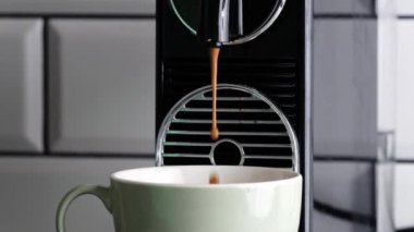 Kahve makinesi sabah kahvaltısı için taze kapuçino hazırlıyor. Sıcak kafein içeceği için espresso dolu kahve fincanı.