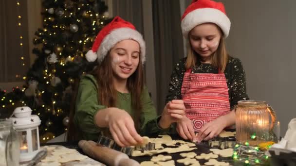 Sisters Santa Hats Cutting Figures Gingerbread Dough Christmas Tree Background — Stock Video