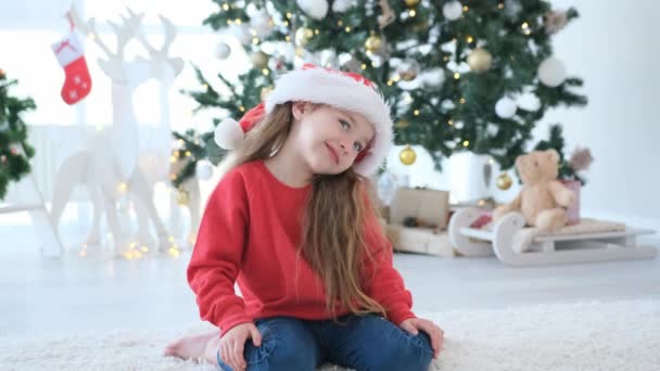 漂亮的小女孩在圣诞快乐的时候 在装饰过的家门口笑着 挂着喜庆的圣诞树 漂亮的孩子在新年摆出姿势 — 图库视频影像