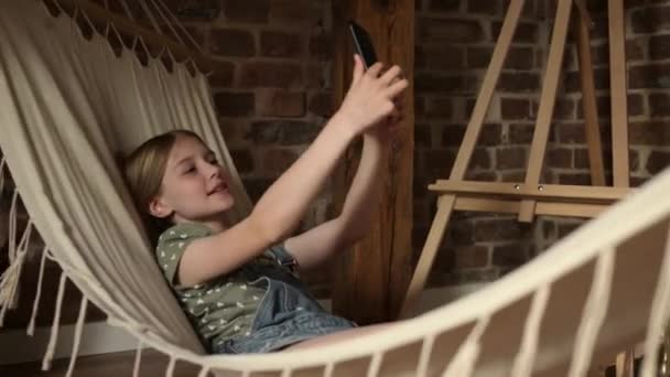 Bambina Preadolescente Sdraiata Sull Amaca Con Smartphone Che Streaming Sui — Video Stock