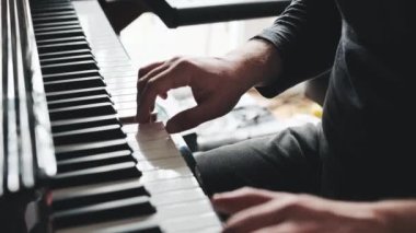 Man hands playing piano keyboard closeup and creating instrumental composition with professional sound. Musician perfomance with classical music on pianoforte