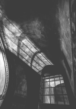 Eski hapishanedeki gizemli bir şato koridorundaki kafesin gölgeleri, siyah ve beyaz.