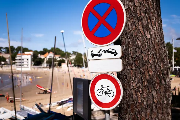Warning sign with bicycle and cars on beach with sea shore view. Bike and transportation restriction notice on ocean coast