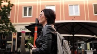 Güneş Gözlüklü Çekici Kadın Sırt çantasıyla Şehirde Yürüyor, Etrafa Bakınan Kadın Turist