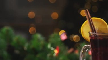 Limon dilimi ve tarçın çubuğuyla süslenmiş kırmızı şarap.