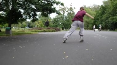 Park 'ta sürat antrenmanı yapan bir kız. Neşeli genç aktif yaz tatilinin tadını çıkarıyor.