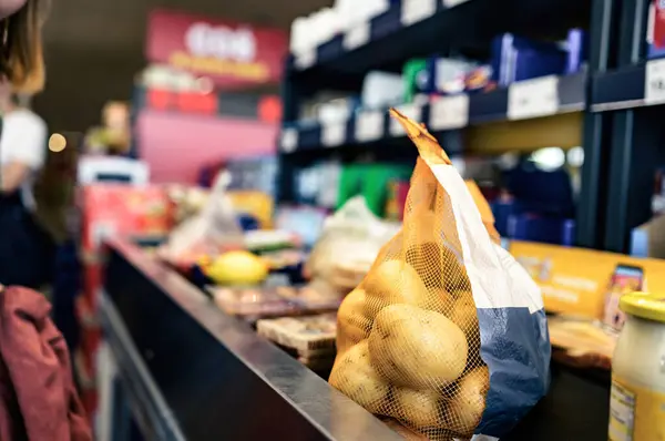 Potato pack net on supermarket shelf. Fresh vegetables divercity in grocery store