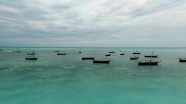 Zanzibar 'ın sahil şeridinin sığ sularında yüzen tahta tekneler.