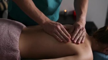 Spa salonundaki masaj prosedürlerini gevşet. Genç bir kız için masaj yapan profesyonel masaj terapisti.