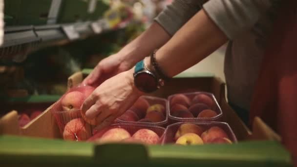 女孩在市场上挑选新鲜的桃子 — 图库视频影像