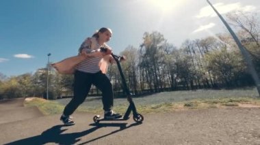 Parkta motosikletle gezen tatlı küçük kız, ağır çekimde.