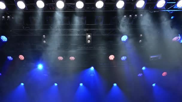 明るい白と青の天井スポットライトは 音楽コンサートやショーの間にステージ霧を通してステージを照らします — ストック動画