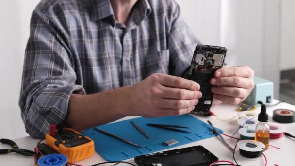Technicien Service Inspecte Ancien Smartphone Avec Écran Cassé Dans Atelier — Video
