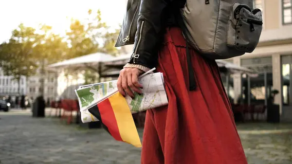 ドレスデンの中央通りの女性観光ストロール 観光でドイツの旗と都市マップを運ぶ — ストック写真