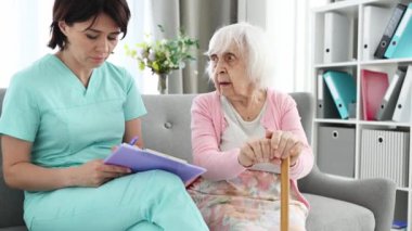 Doktor, büyük parlak bir odada, küçük bir koltukta yaşlı kadınların şikayetlerini kaydetti.