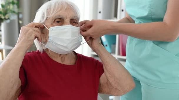 Infermiera Aiuta Donna Anziana Indossare Maschera Protettiva Medica Durante Periodo — Video Stock