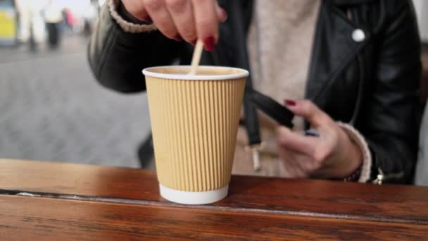 세련된 여성은 그녀의 커피를 즐깁니다 테이블에 일회용 종이컵에서 — 비디오