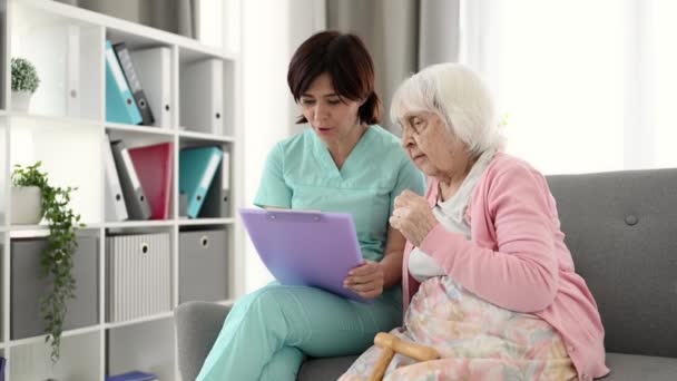 Enfermera Lee Información Médica Mujer Mayor Habitación Del Hogar Ancianos — Vídeos de Stock