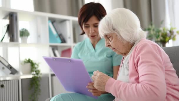 Enfermera Ayuda Anciana Firmar Documentos Salud Habitación Brillante — Vídeos de Stock