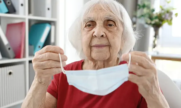 Elderly Woman Puts Protective Medical Mask Face — Stock Photo, Image