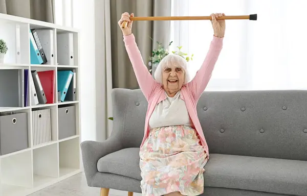Elderly Woman Lifts Walking Cane Upwards Symbolizes Victory Over Disease
