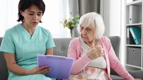 Γιατρός Διαβάζει Ηλικιωμένη Γυναίκα Έγγραφα Υγείας Φωτεινό Διάδρομο — Αρχείο Βίντεο