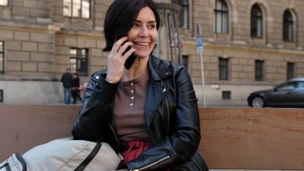 Atractiva Mujer Sonriente Disfruta Una Conversación Amistosa Mientras Habla Por — Vídeo de stock