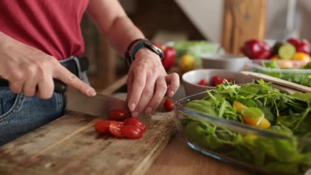 女孩在厨房的切菜板上切樱桃西红柿 — 图库视频影像