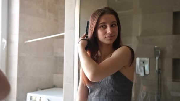 Έφηβη Κοπέλα Τρίβει Μαλλιά Της Στον Καθρέφτη Του Μπάνιου Μέρος — Αρχείο Βίντεο