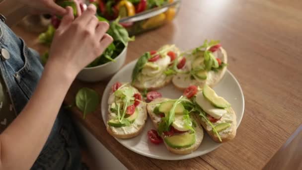 小女孩用菠菜装饰健康新鲜三明治 健康蔬菜三明治与奶酪番茄和鳄梨 — 图库视频影像