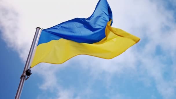 ウクライナの国旗を青空の背景に掲げるフラッグポールのスタンドに掲げる — ストック動画