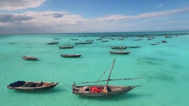 Sakin bir okyanus yüzeyinde yüzen ahşap botları olan şaşırtıcı deniz manzarası Zanzibar kıyı şeridi