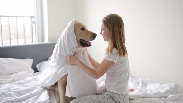 快乐的小女孩 带着她的金毛猎犬 裹在毛毯里 玩得很开心 — 图库视频影像