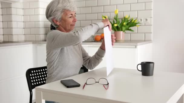 Cheerful Elderly Lady Unwraps Envelope Containing Documents Papers Home — Stock Video
