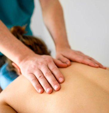 Spa kliniğinde boyun ve omuz masajı yapılan bir kız. Masör elleri, genç kadın sağlığı ve rahatlığı için vücut terapisi prosedürü uyguluyor..