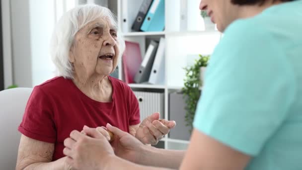 护士在谈话中支持老年妇女并握住她的手 — 图库视频影像