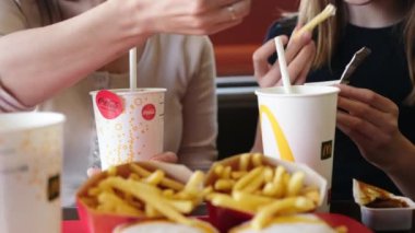 Poznan, Polonya - 28 Nisan 2024: Anne ve Küçük Kızı McDonalds Fast Food Lokantasında Kızarmış Patates ve Sodanın keyfini çıkarıyorlar