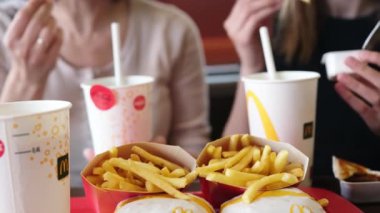 Poznan, Polonya - 28 Nisan 2024: Anne ve Küçük Kızı McDonalds Fast Food Lokantasında Kızarmış Patates ve Sodanın keyfini çıkarıyorlar