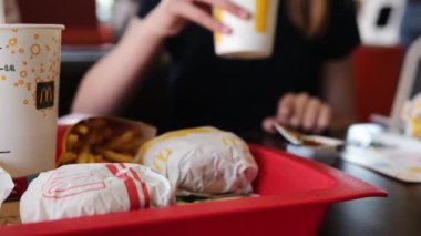 Poznan, Polonya - 28 Nisan 2024: McDonalds Fast Food Lokantasında Küçük Kız Soğuk Soda İçiyor