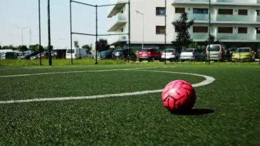 Küçük futbolcu topa vurarak gol atıyor.