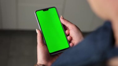 Elinde Yeşil Ekran Kromakey Akıllı Telefonu tutan ve ona bakan Kız