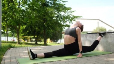 Fit bir kız sabah rutininin bir parçası olarak parkta gerilip ayrılıyor.