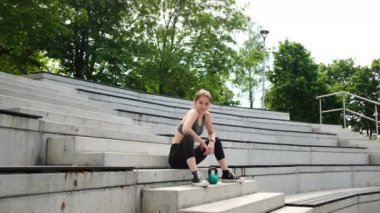 Parkın içinde Kettlebell kullanarak spor yapan formda bir kız.