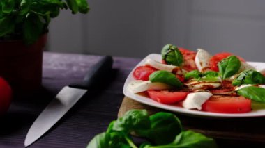 Mutfak masasında taze Mozzarella soslu geleneksel vejetaryen Caprese salatası.