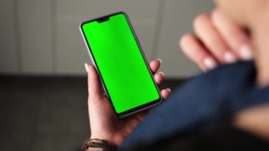 Elinde Yeşil Ekran Kromakey Akıllı Telefonu tutan ve ona bakan Kız