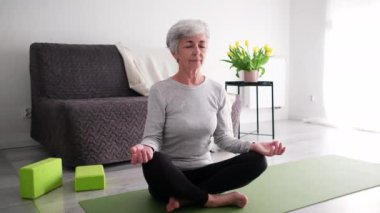 Evde yoga yapan yaşlı aktif bayan.