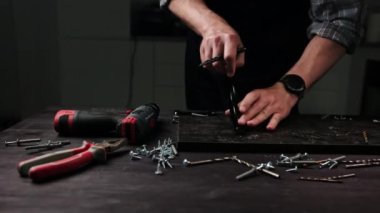 Usta mobilya için metal desteğini beceriyor.