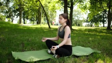 Şirin, zinde ve sakince Yoga yapan Nilüfer Pozu 'nda nefes almaya odaklanan genç bir kız.