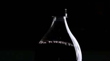 Siyah bir arka planda sıfır şekerli diyet kola şişesi.