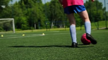 Genç kız futbol antrenmanında topu tutmayı öğreniyor.